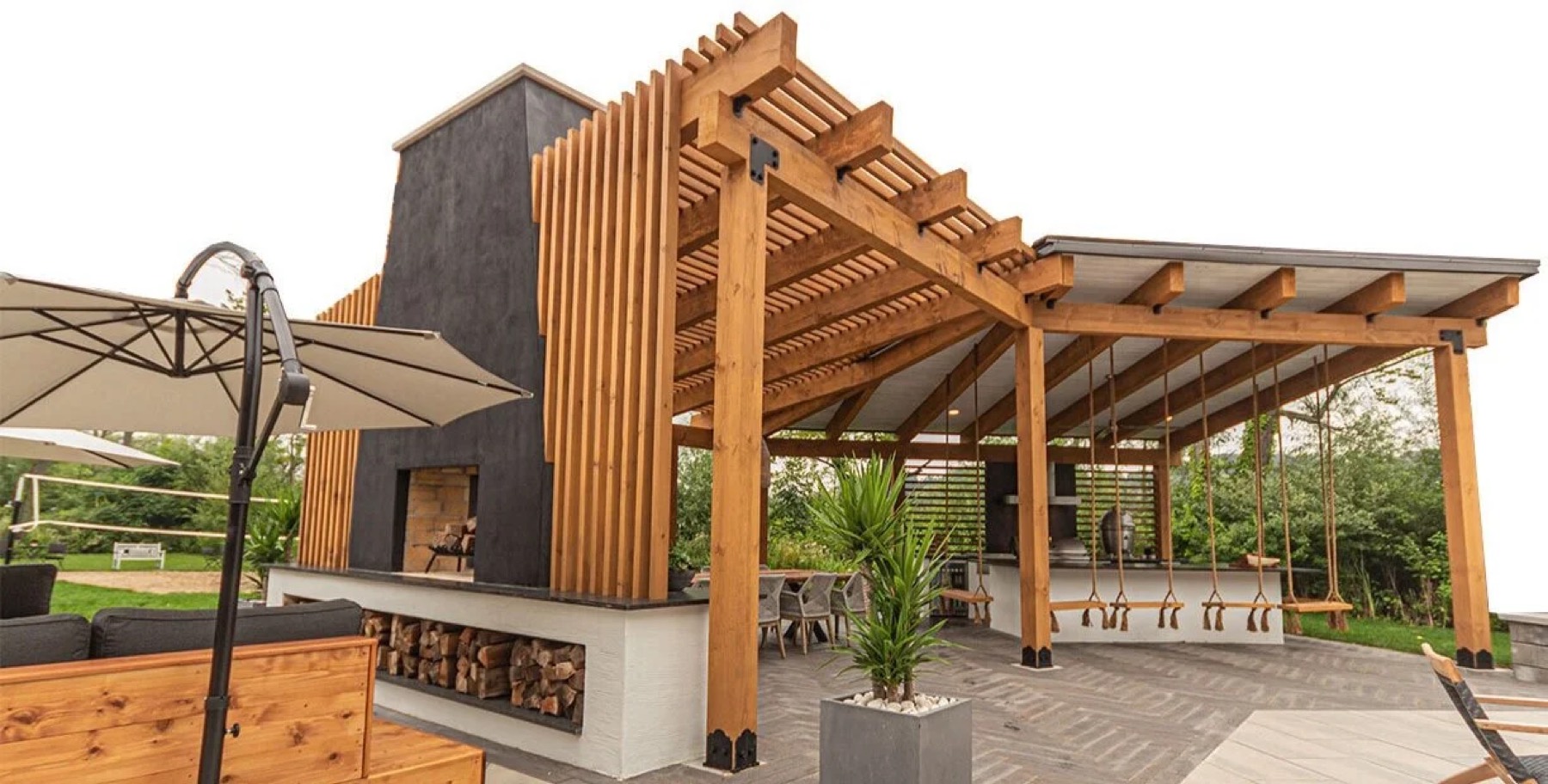 Custom pergola over an outdoor kitchen with built-in fireplace